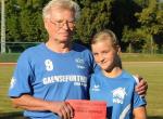 Übungsleiter Joachim Rösler  überreichte Alina für ihre Leistung einen Gutschein vom Sporthaus Koppius. Foto: N. Wulf, Volksstimme
