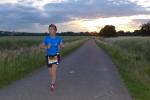 Während Sabine Börner die ersten leichten Kilometer abspult, geht hinter ihr die Sonne auf.