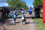 Während „die Großen“ bereits ihren Wettkampf hinter sich hatten, flitzt Linnart (re.) beim Quedel-Lauf der Kindergartenkinder über die Ziellinie. Coach Oma freut sich im Hintergrund.