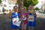 Lenya Schielke und Rieke Lucie Zaschke verputzen ihre Lorbeeren direkt nach dem Zieleinlauf (v.l.). Jette Emilia Zaschke (m.) passt derweil auf das neue Gaense-Maskottchen auf.